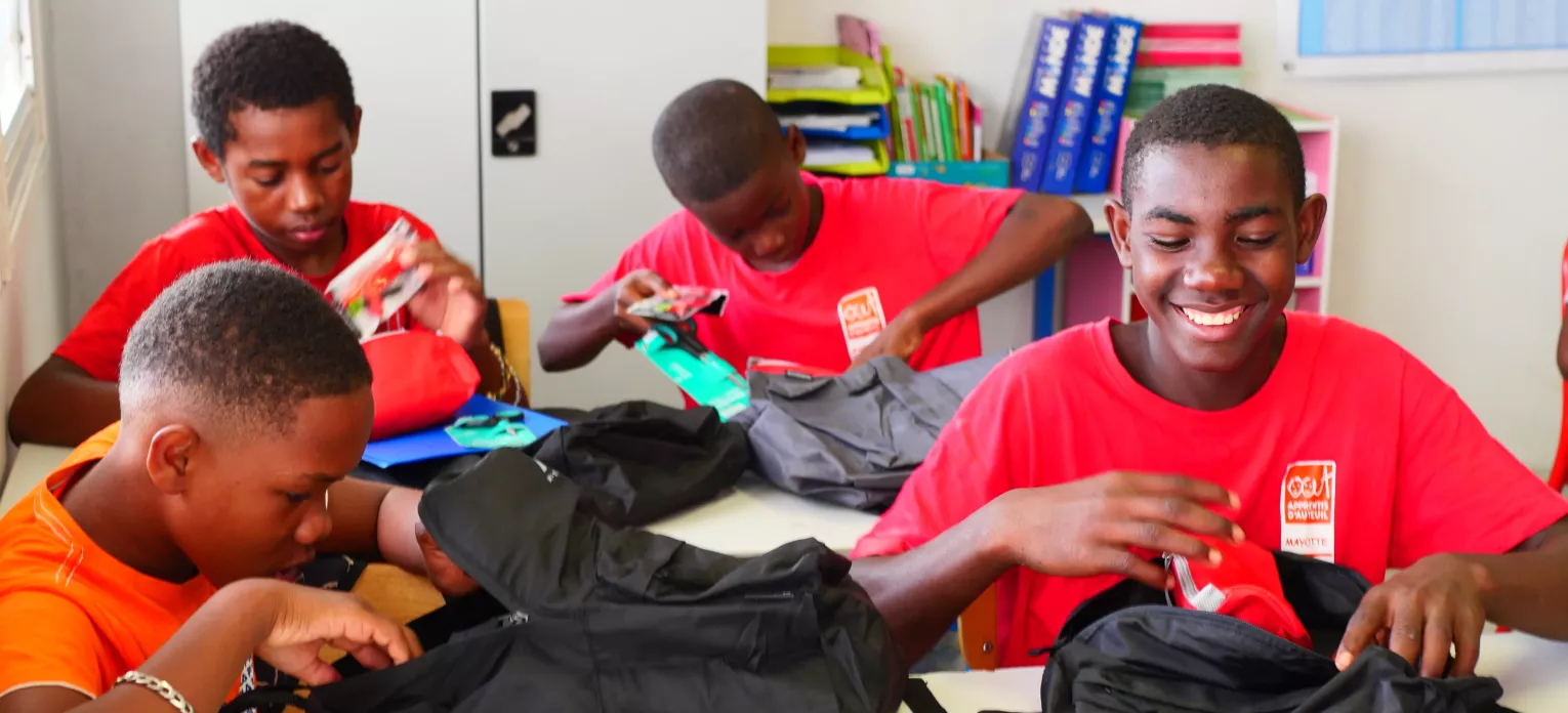 groupe de jeunes qui ouvrent leurs cartables 