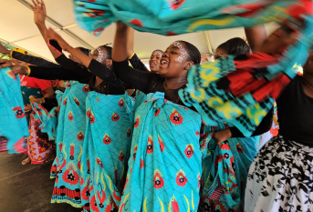 Groupe de jeunes filles qui dansent en agitant des tissues bleus