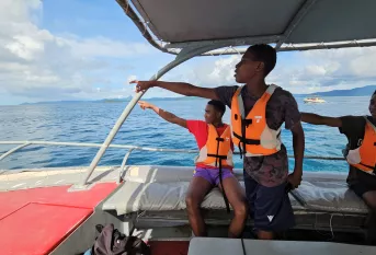 Groupes de garçons sur un bateau montrant le large 