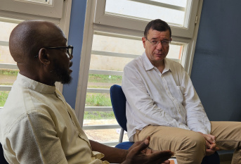 Deux hommes conversent assis dans un bureau
