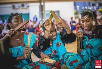 Trois jeunes filles chantent et jouent du Mbiwi