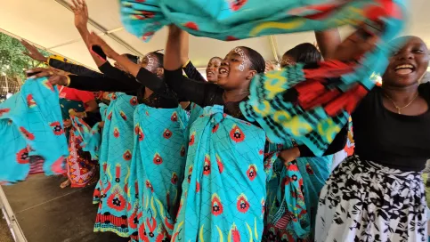 Groupe de jeunes filles qui dansent en agitant des tissues bleus 