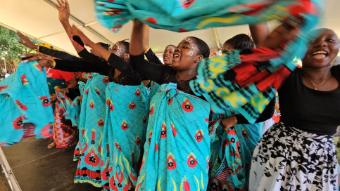 Groupe de jeunes filles qui dansent en agitant des tissues bleus