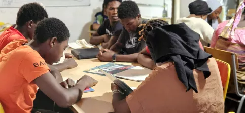 groupe de jeunes qui lisent assis autour d'une table