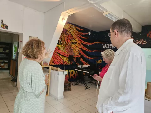 3 personnes sont dans une pièce avec en train de discuter 