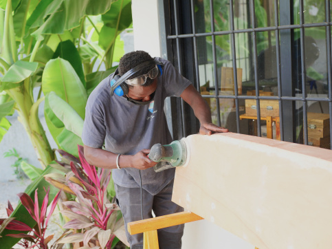 Un jeune homme ponce une pirogue