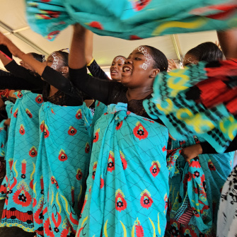 Groupe de jeunes filles qui dansent en agitant des tissues bleus 