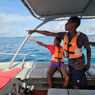 Groupes de garçons sur un bateau montrant le large 