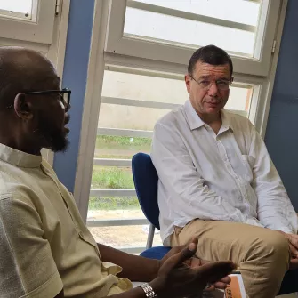 Deux hommes conversent assis dans un bureau