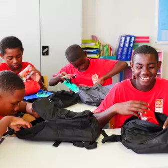 groupe de jeunes qui ouvrent leurs cartables 