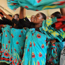 Groupe de jeunes filles qui dansent en agitant des tissues bleus 