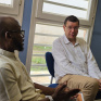 Deux hommes conversent assis dans un bureau